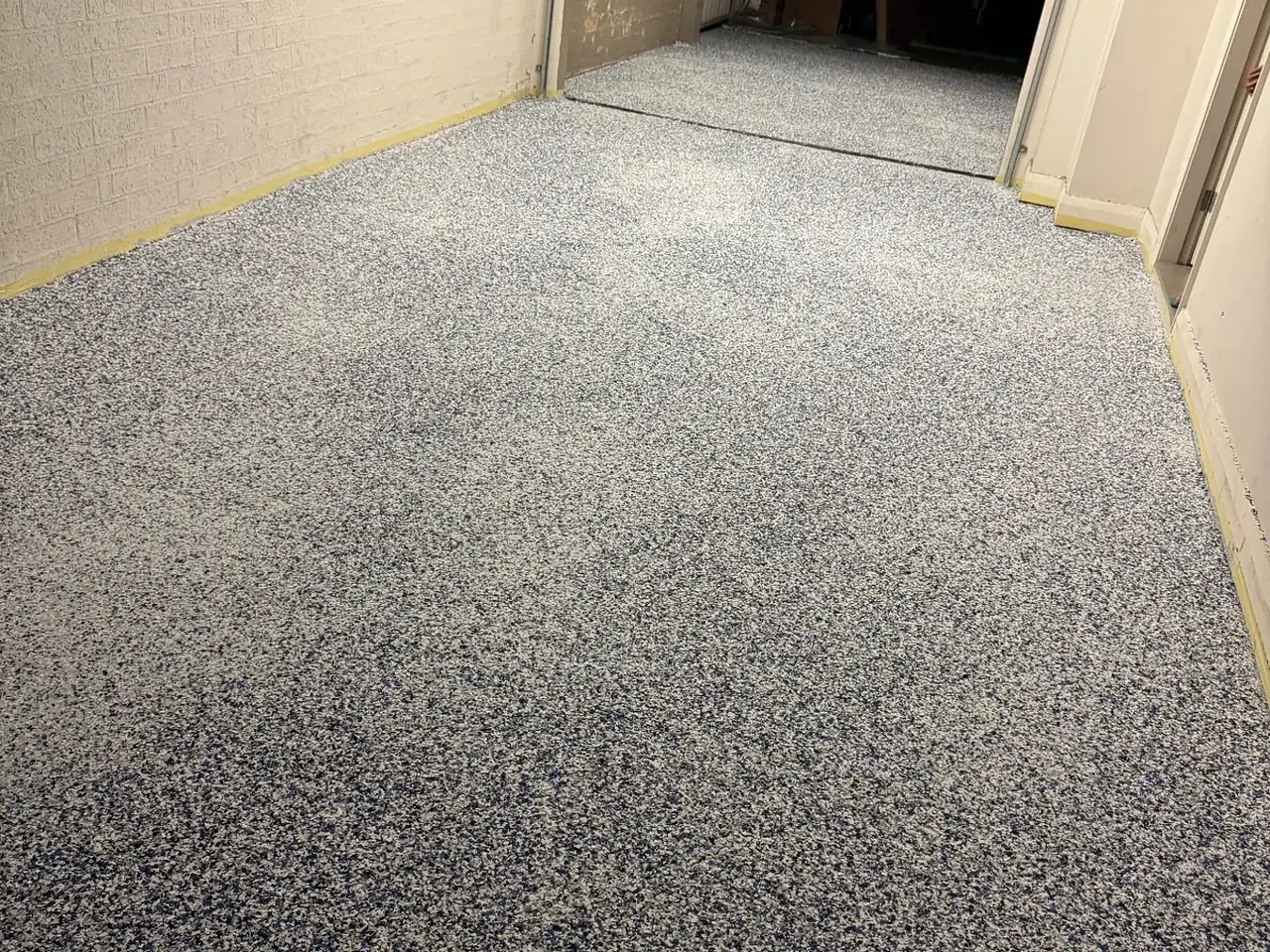 Grey-blue flake epoxy floor in a long garage corridor — King of Seal Sydney