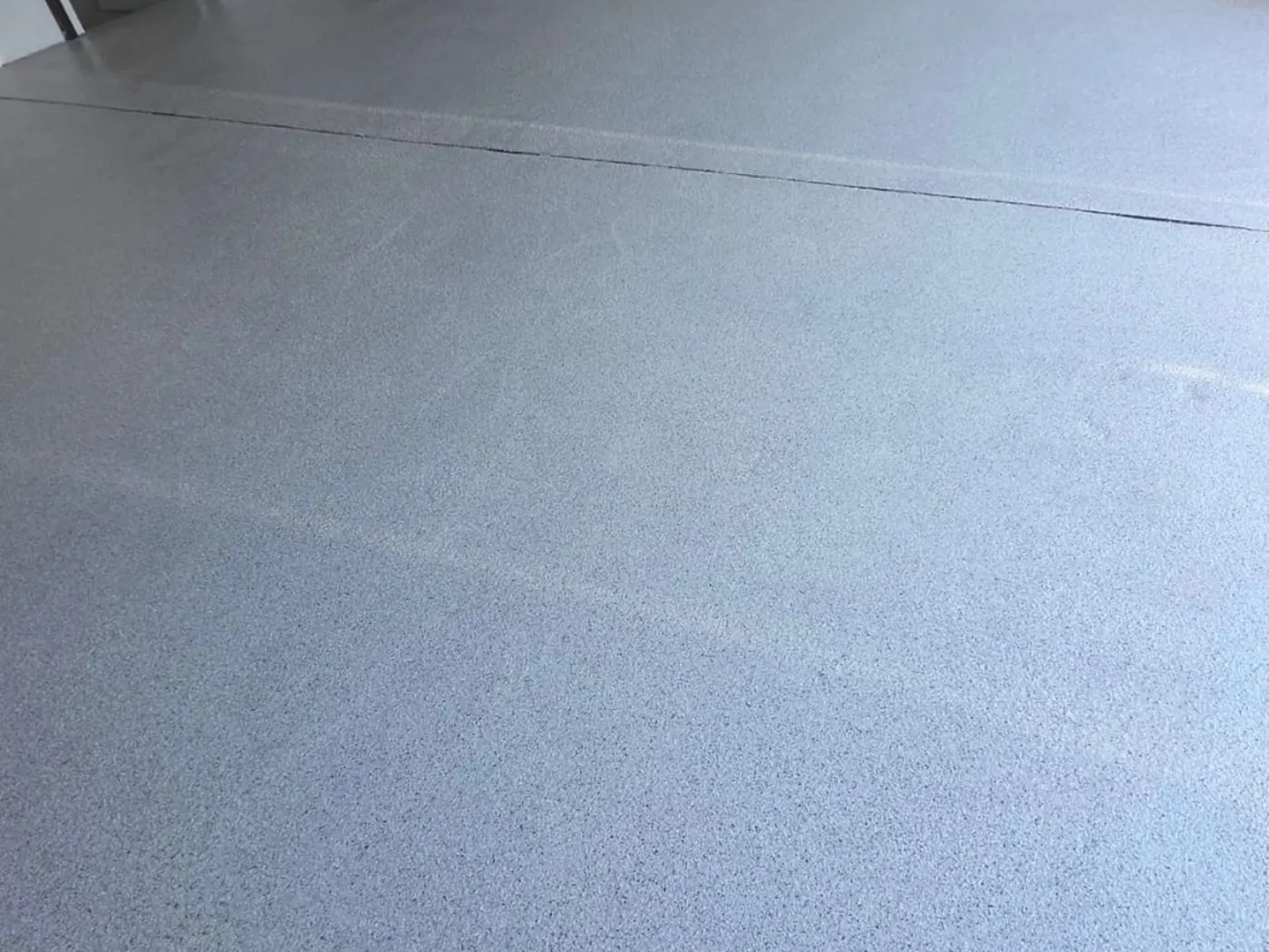 Grey flake epoxy floor in a residential garage with hot water tank — King of Seal Sydney