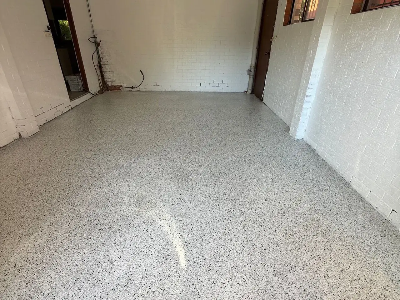 Flake epoxy floor in a white-walled residential garage — King of Seal Sydney