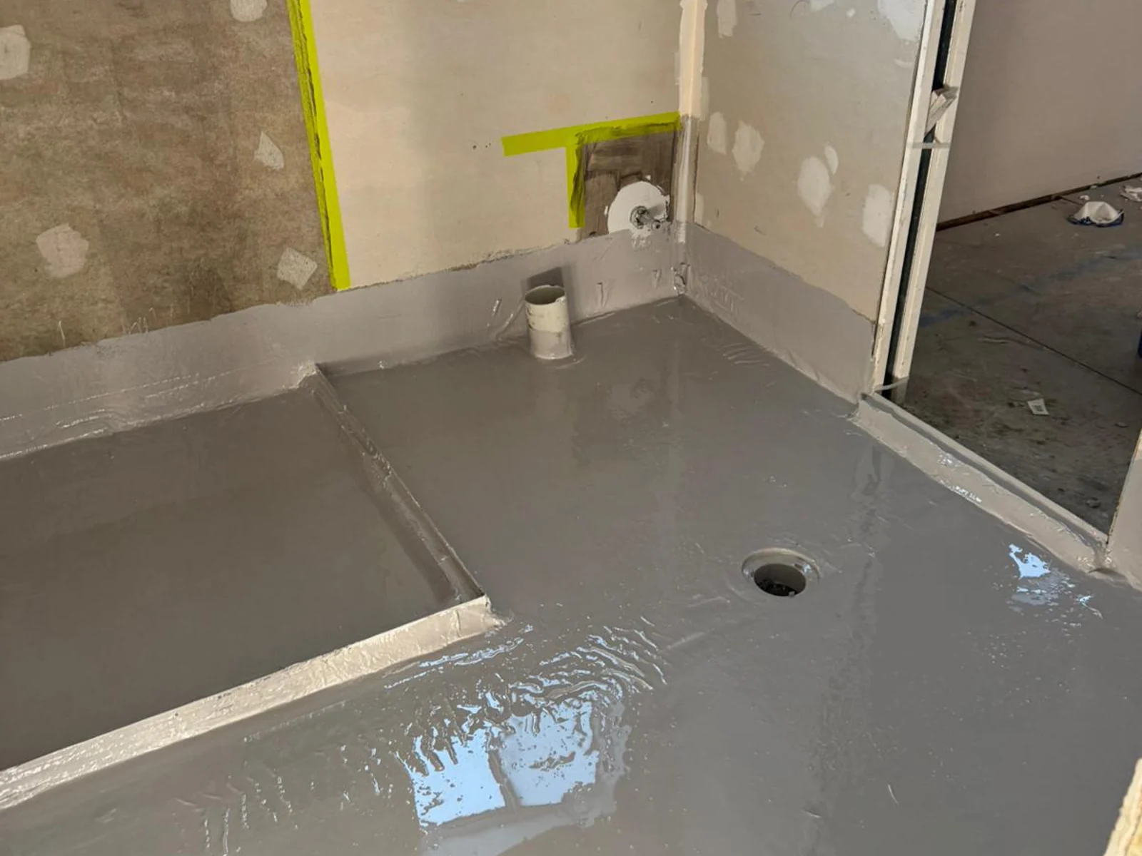 Bathroom floor with grey waterproofing membrane applied around drain and shower hob — King of Seal Sydney