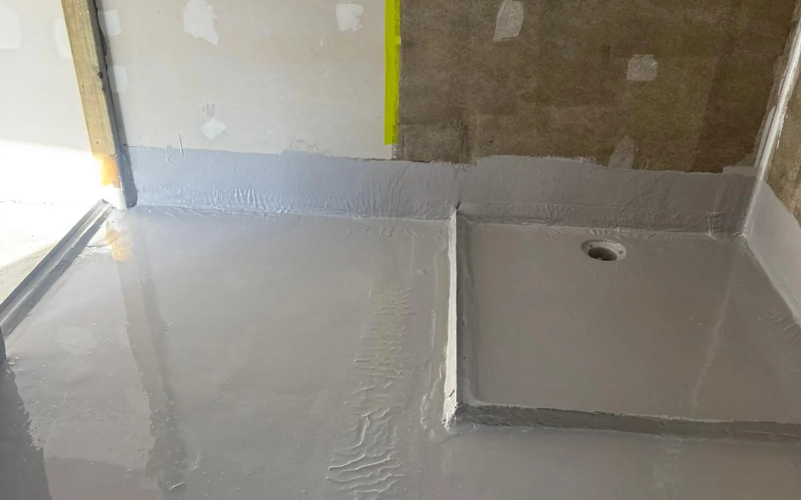 Bathroom shower base with grey waterproofing membrane applied to floor and walls — King of Seal Sydney